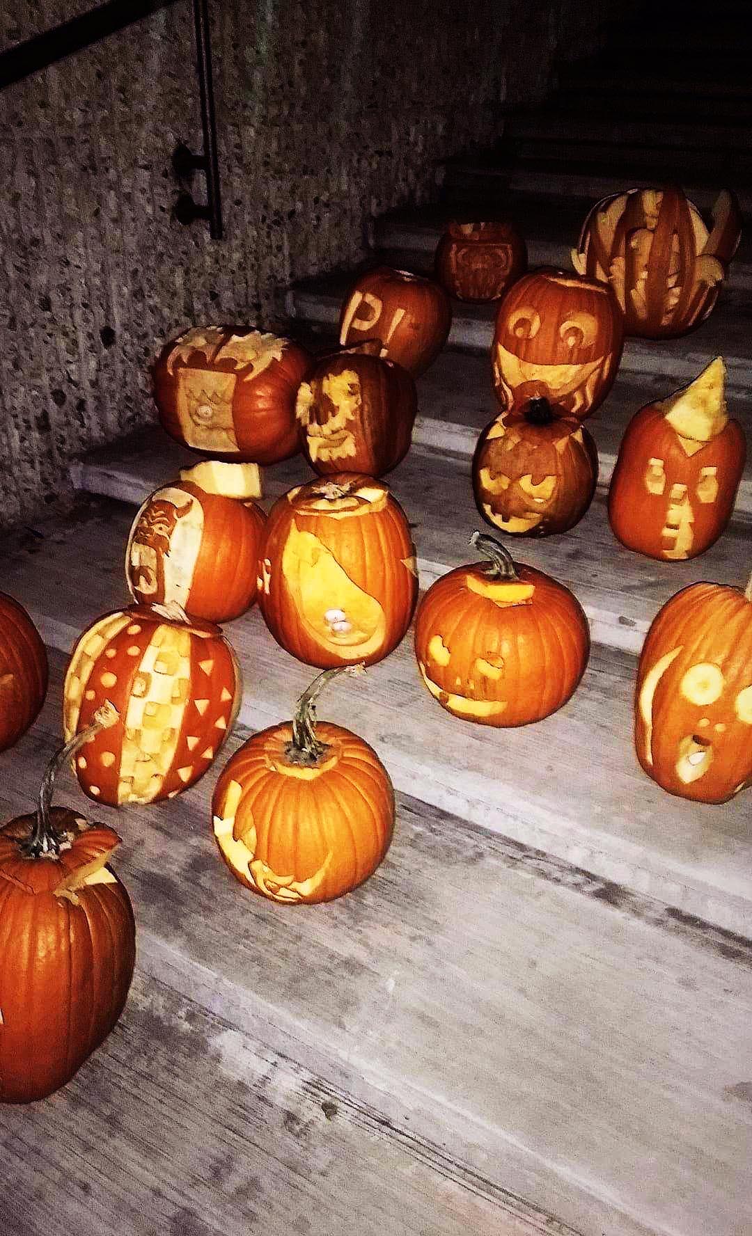 Carved Halloween jack-o'-lantern pumpkins glowing at night
